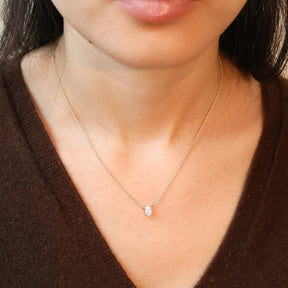 Model draagt een 14 karaat gouden ketting met ovale diamant van 0.3 karaat